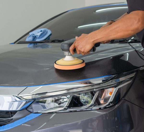 Car detailing - Male mechanic holding car polishing machine. Auto industry, car polishing and painting and repair shop.